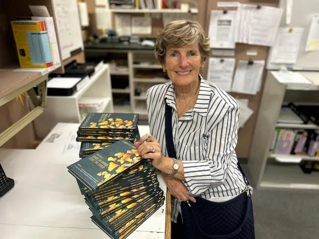 Author Mary Lea Carroll holding copies of her book