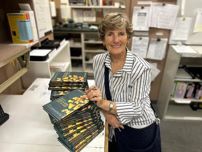 Author Mary Lea Carroll holding copies of her book