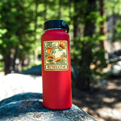 Altadena Poppy sticker applied to a red water bottle