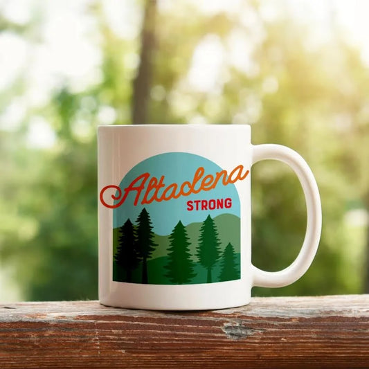 Altadena Strong ceramic mug outdoors on a wooden table