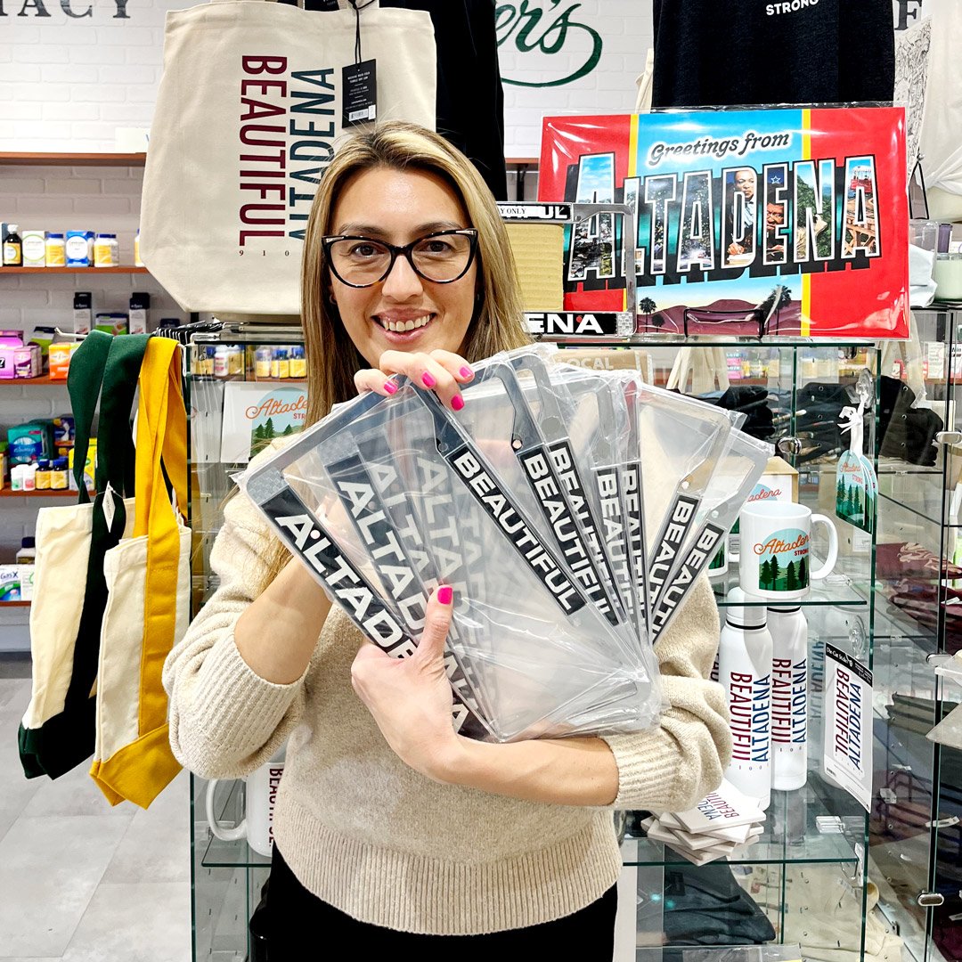 Customer holding Beautiful Altadena license plate frames in the store