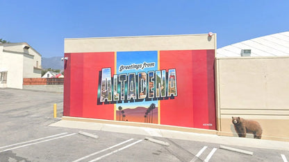 Greetings From Altadena mural poster shown painted on an exterior wall
