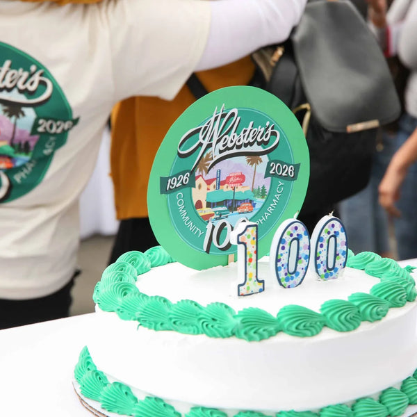 Webster's Pharmacy 100th anniversary cake with green trim and 100 candles