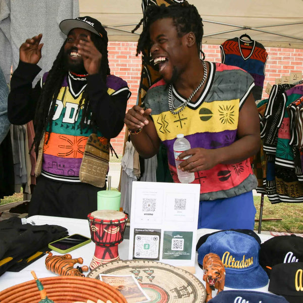 Vendors laughing at their colorful apparel booth at Webster's street fair