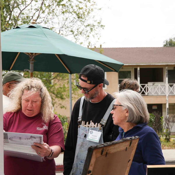 Artist sharing sketches with visitors at Webster's 100th anniversary street fair
