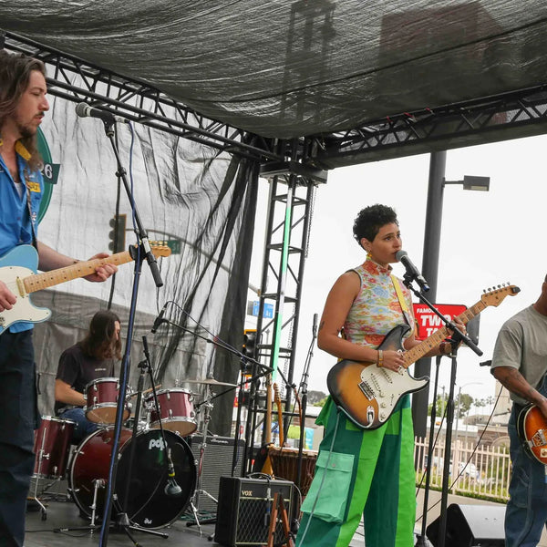Band playing guitars on stage at Webster's centennial celebration in Altadena