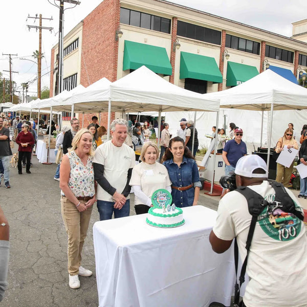 Guests photographing the Webster's 100th anniversary cake at the street fair