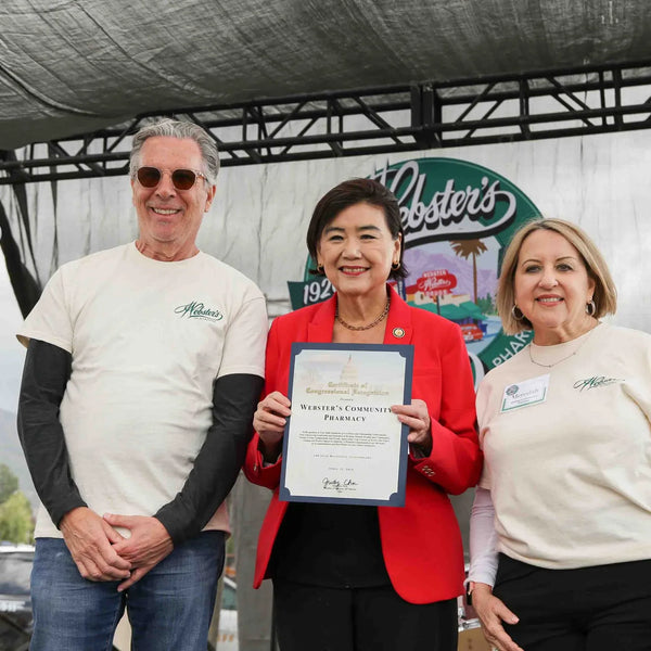 Certificate of recognition presented to Webster's Pharmacy owners on the anniversary stage
