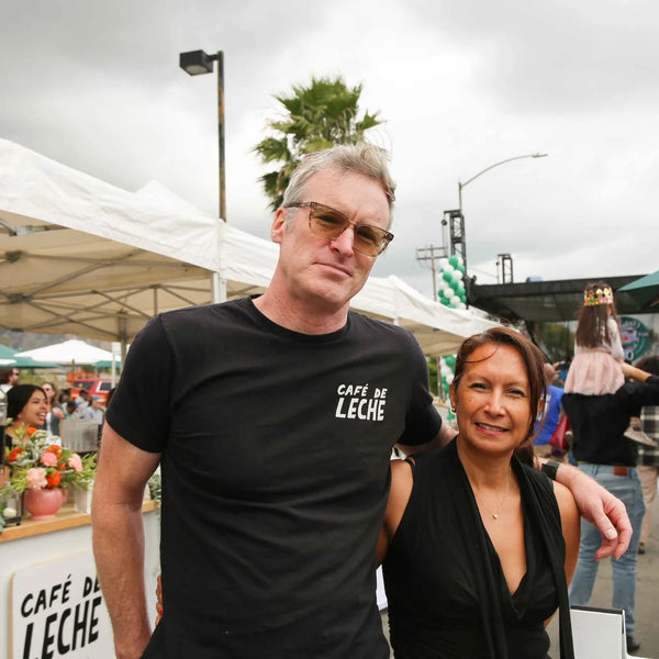 Couple posing at the Cafe de Leche coffee stand at Webster's anniversary fair