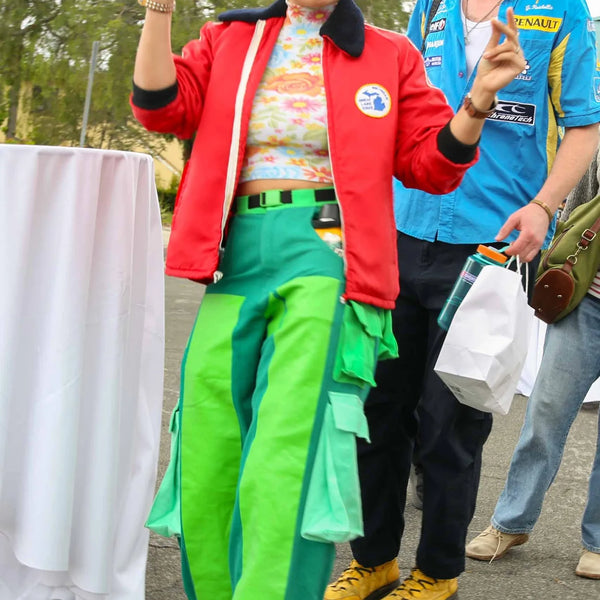 Guest in a bright outfit waving at Webster's centennial fair in Altadena