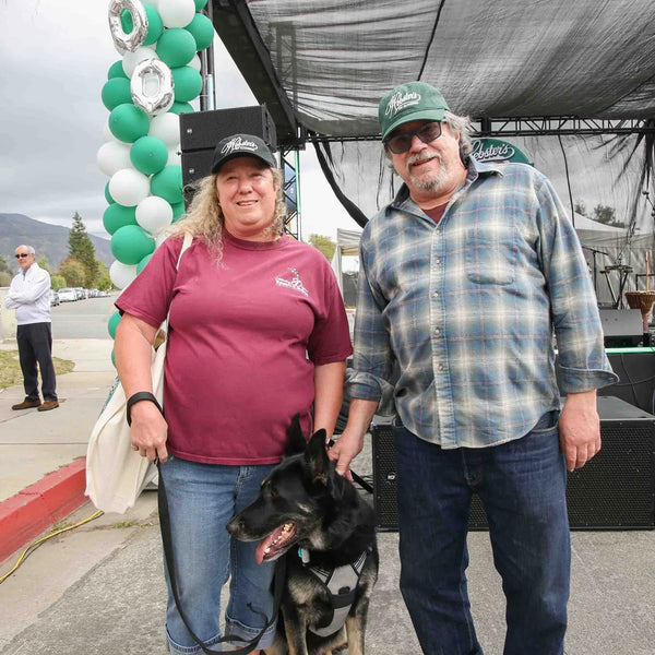 Couple with their dog by the balloon-decorated stage at Webster's street fair