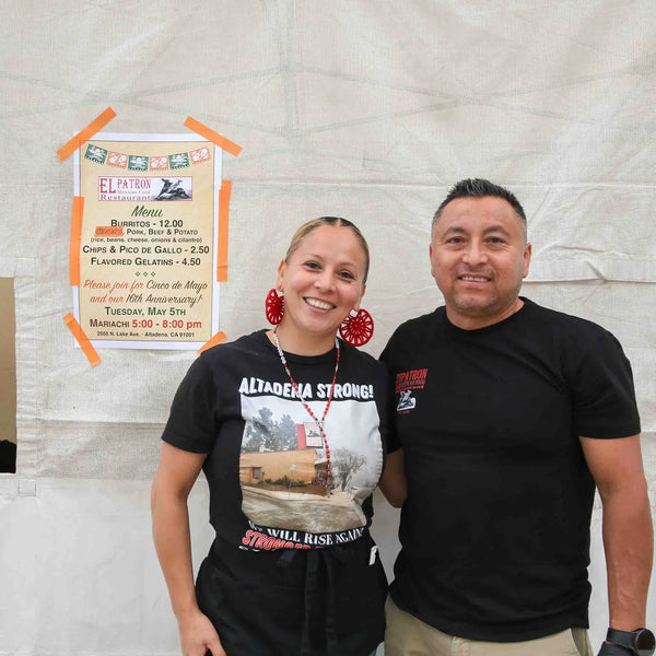 Couple smiling in front of the food tent at Webster's 100th anniversary fair