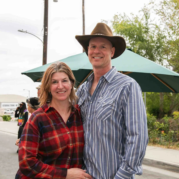 Couple posing under a green umbrella at Webster's 100th anniversary fair