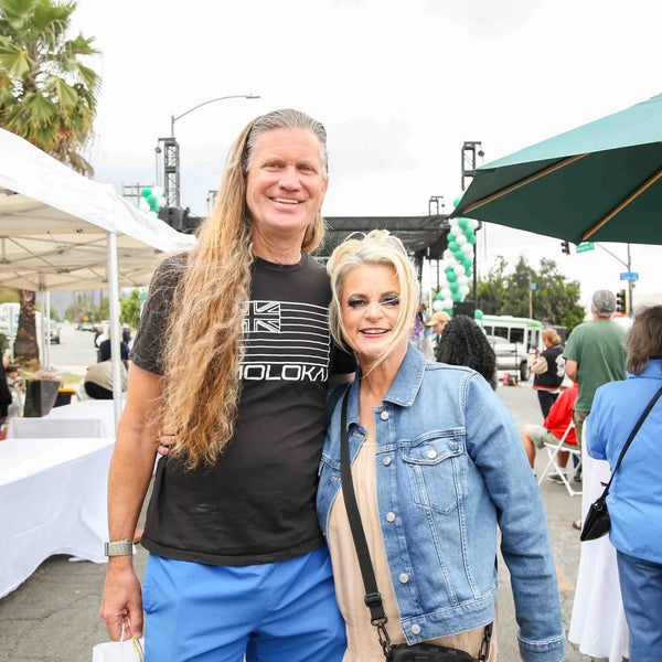 Couple posing along the vendor row at Webster's anniversary street fair