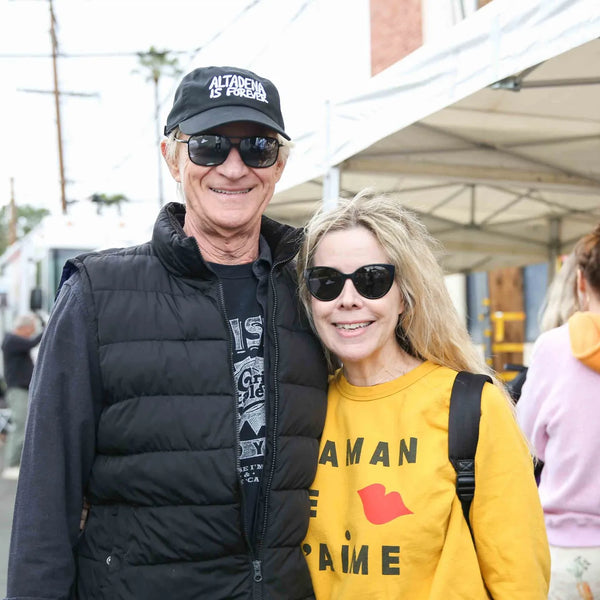 Couple smiling along the vendor row at Webster's anniversary street fair