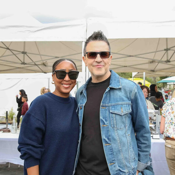 Couple smiling among vendor tents at Webster's 100th anniversary fair