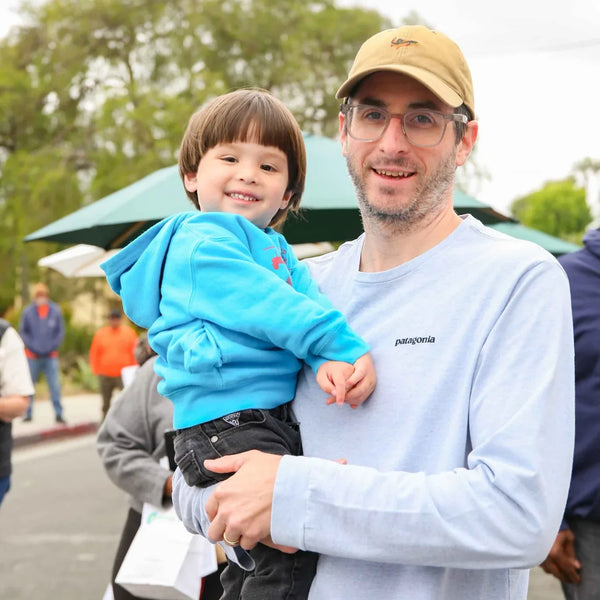 Dad holding his toddler at Webster's 100th anniversary street fair