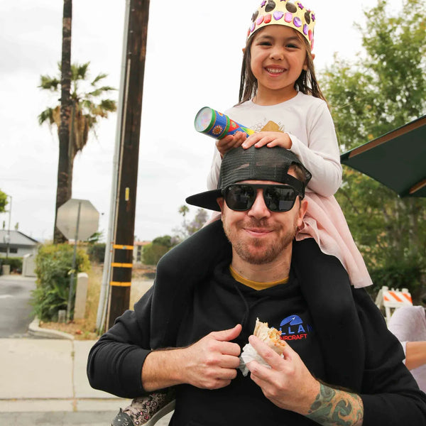 Girl riding on her dad's shoulders at Webster's 100th anniversary street fair