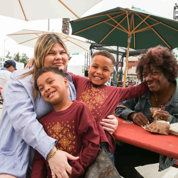 Family with kids gathered at a picnic table at Webster's anniversary fair