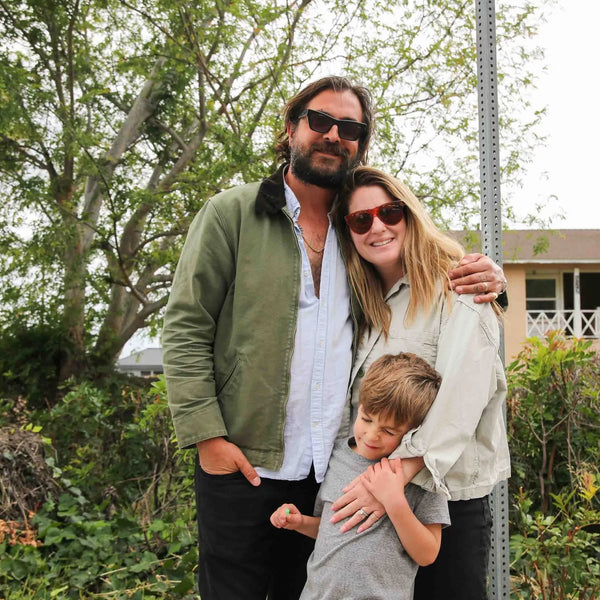 Family of three embracing at Webster's 100th anniversary fair in Altadena