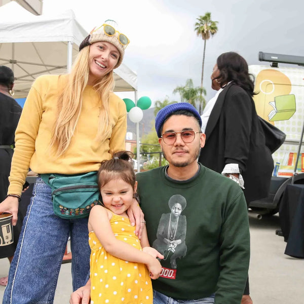 Family posing near the outreach booths at Webster's anniversary celebration