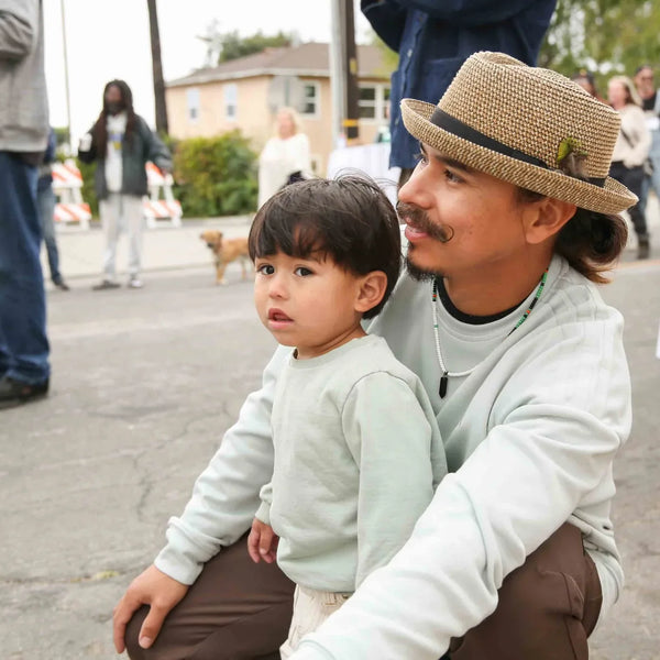 Father in a straw hat with his son at Webster's 100th anniversary fair