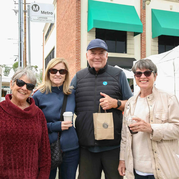 Four friends with coffee enjoying Webster's 100th anniversary fair in Altadena