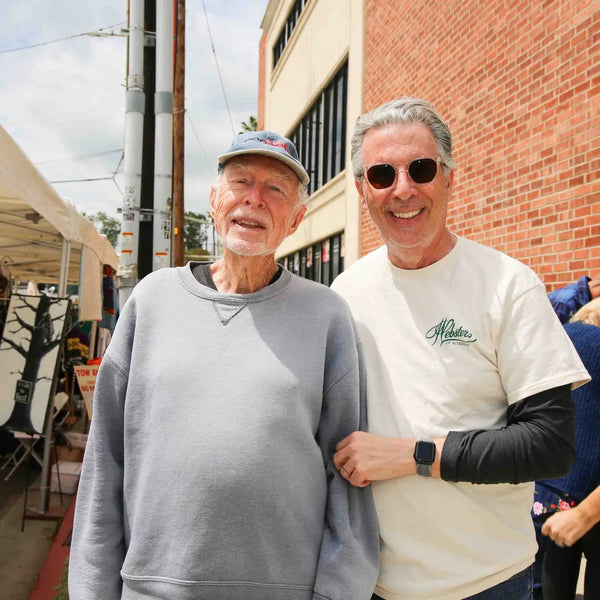 Two friends arm in arm along the vendor row at Webster's centennial celebration