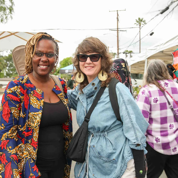 Two friends in colorful outfits at Webster's 100th anniversary celebration
