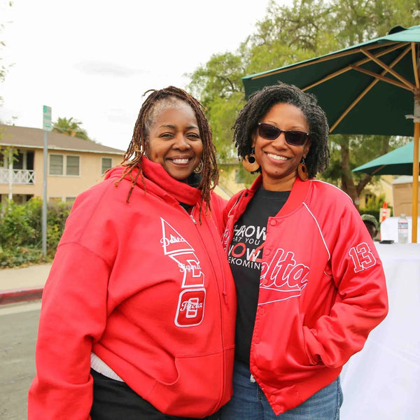 Two friends in red jackets posing at Webster's 100th anniversary street fair