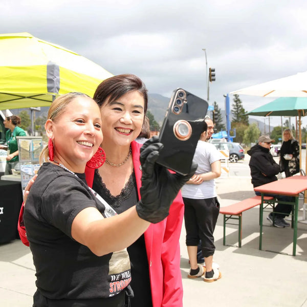 Two friends taking a selfie at Webster's Community Pharmacy centennial celebration