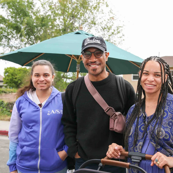 Three attendees with a stroller enjoying Webster's 100th anniversary street fair
