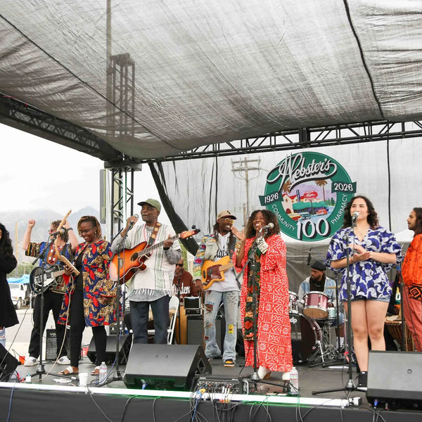 Full band in colorful outfits performing at Webster's centennial stage