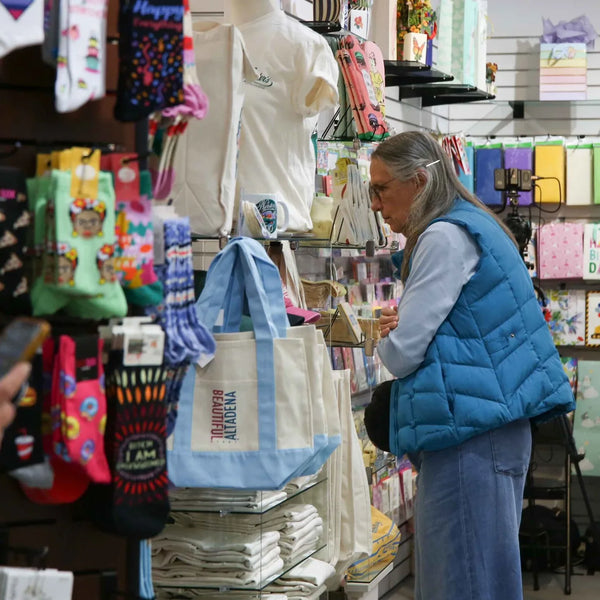 Shoppers browsing socks, totes and gifts inside Webster's Community Pharmacy in Altadena