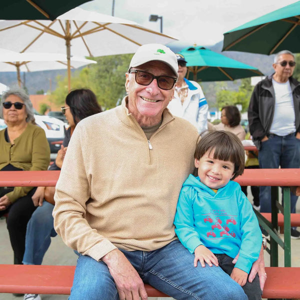 Grandfather with his grandchild on a bench at Webster's street fair