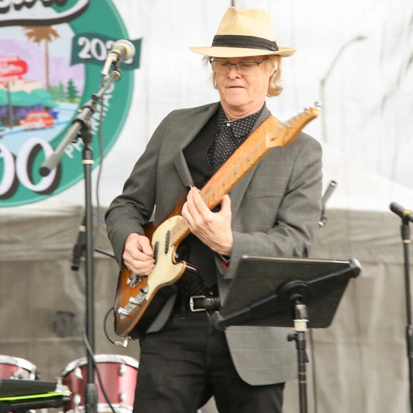Guitarist in a straw hat performing at Webster's 100th anniversary fair
