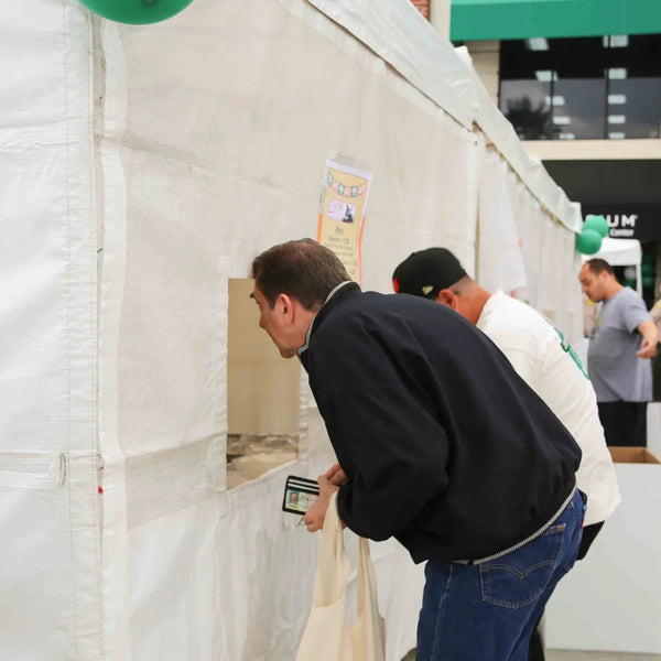 Visitors viewing the history exhibit tent at Webster's Pharmacy anniversary celebration