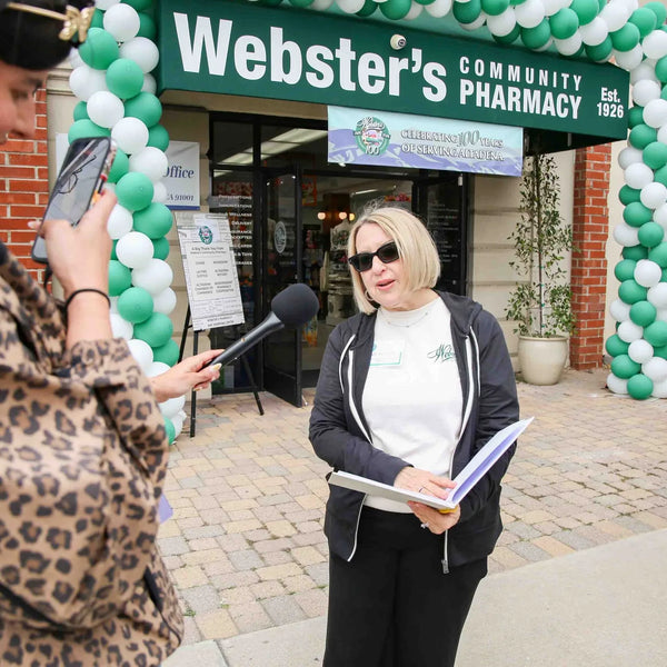 Interview beneath the balloon arch outside Webster's Community Pharmacy