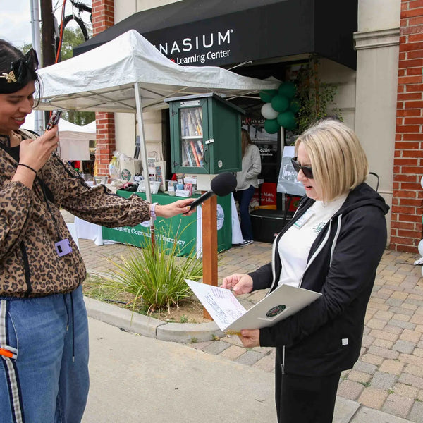 Guest interviewed outside Webster's Community Pharmacy during the fair