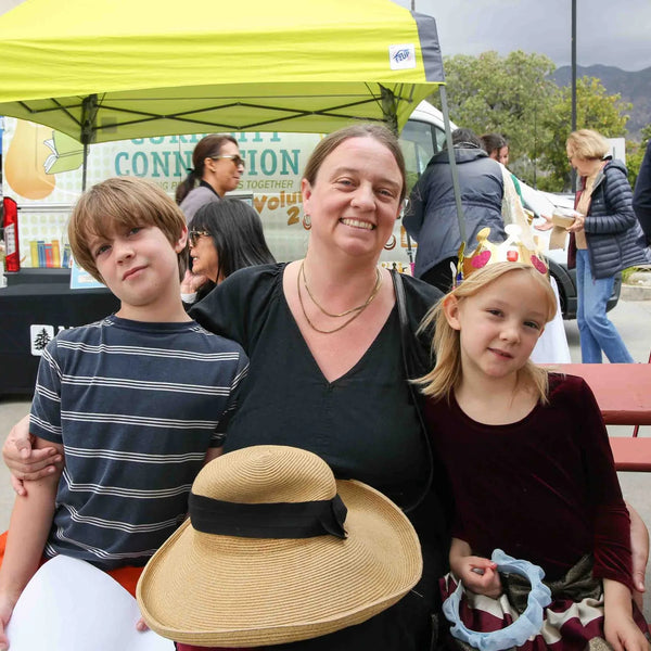 Mom with her two kids at a picnic table at Webster's 100th anniversary fair