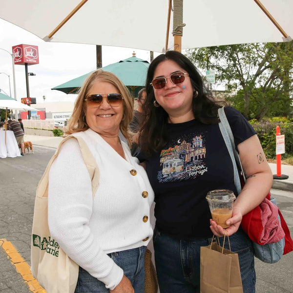 Mother and daughter with a tote bag at Webster's anniversary fair in Altadena