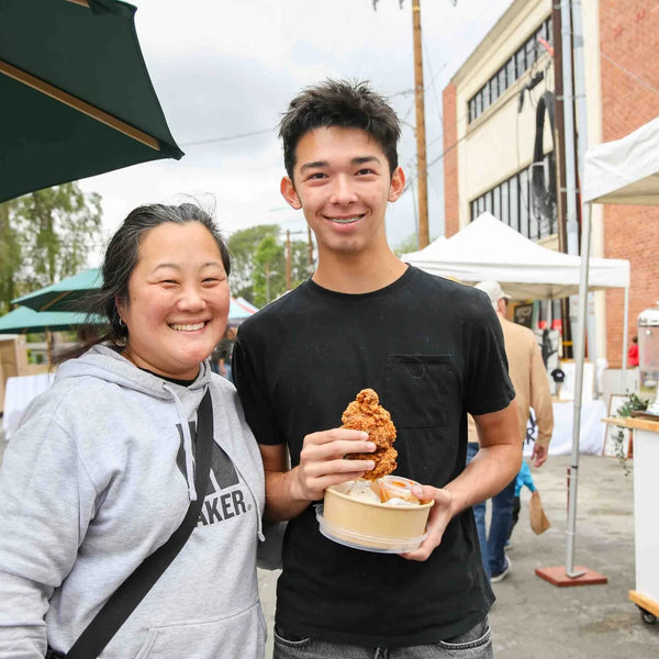 Mother and son with a pastry by the Cafe de Leche cart at Webster's fair