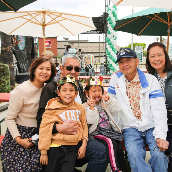 Multigenerational family gathered at picnic tables during Webster's anniversary fair