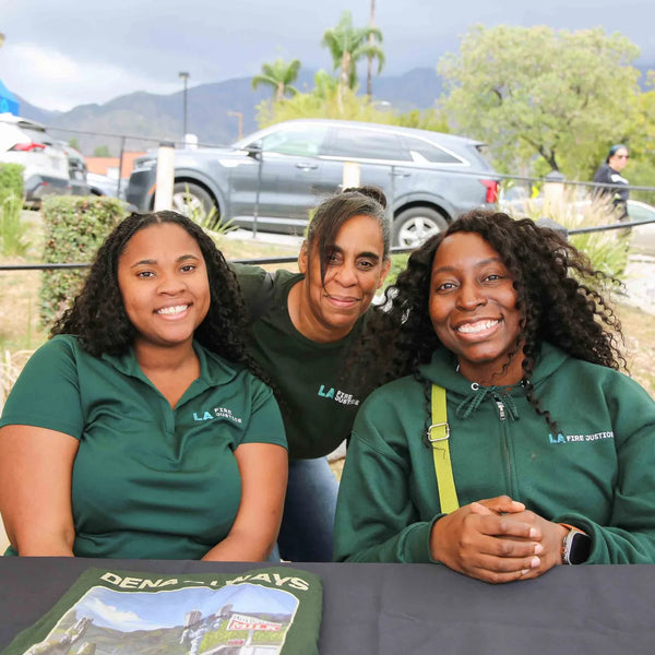 Community outreach team smiling at their table during Webster's street fair