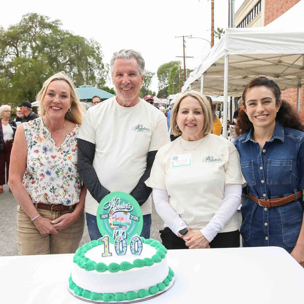 Webster's Pharmacy owners gathered around the 100th anniversary cake