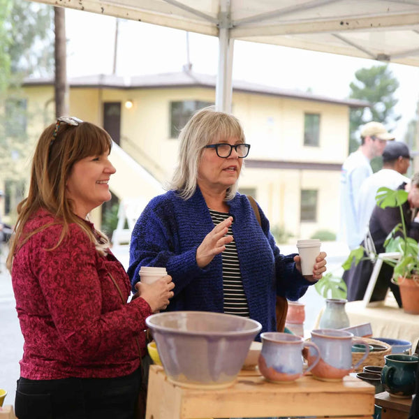 Two guests chatting at the plant booth during Webster's anniversary fair