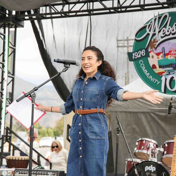 Performer on stage beneath the Webster's 1926-2026 centennial logo
