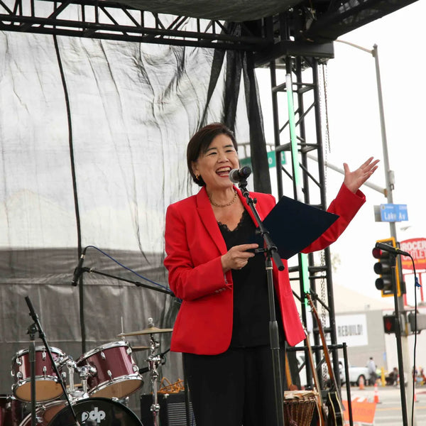 Guest speaker welcoming the crowd on stage at Webster's Pharmacy centennial celebration