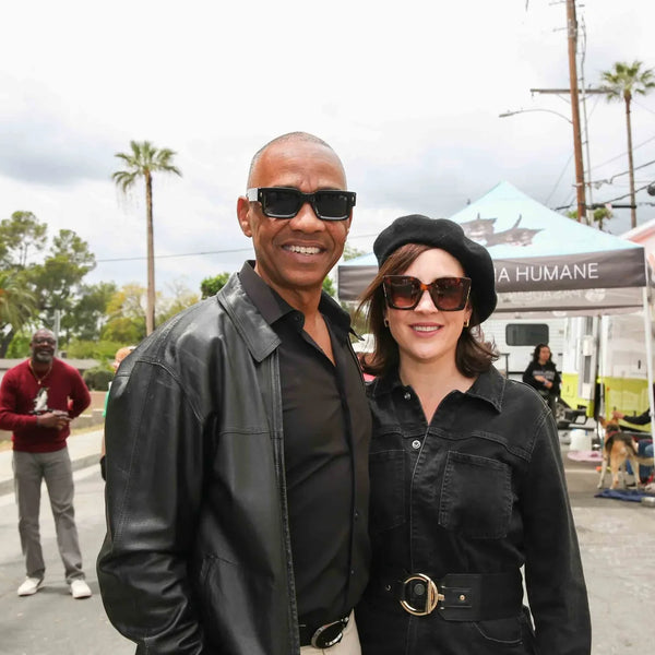 Stylish couple posing near the pet adoption van at Webster's anniversary street fair