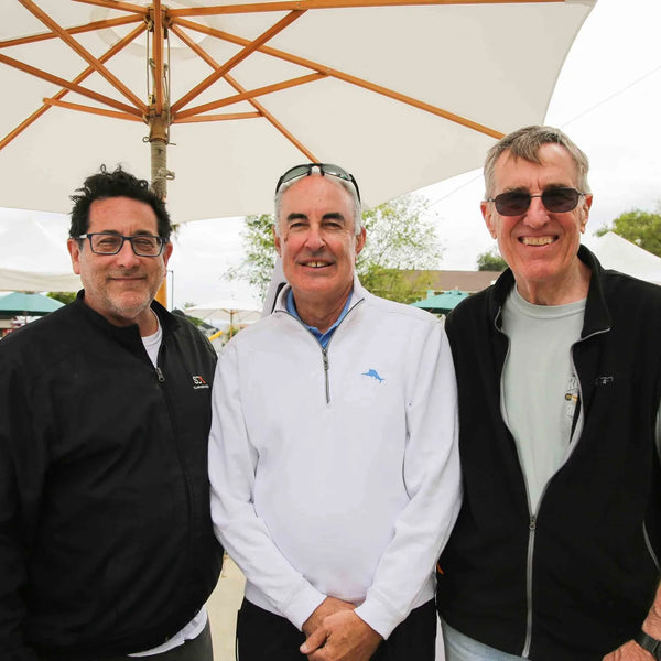 Three friends under an umbrella at Webster's 100th anniversary street fair